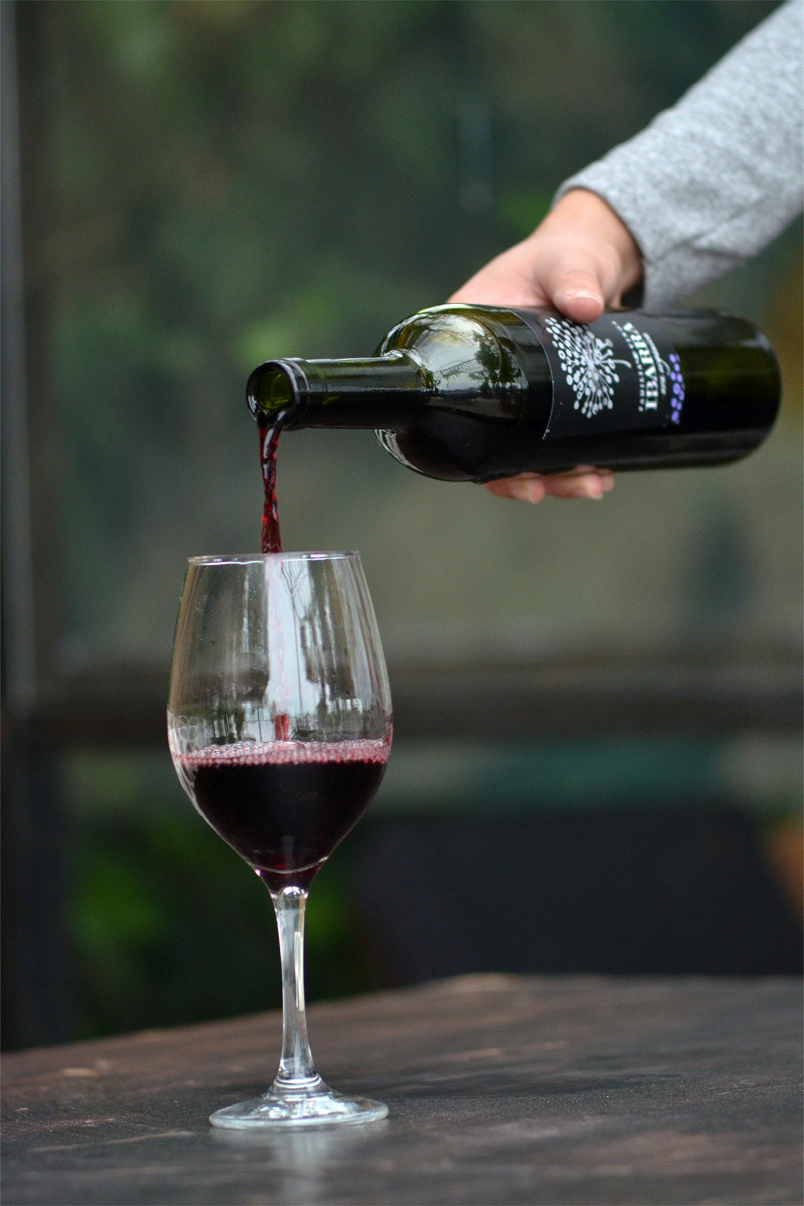 Rotwein wird in ein Glas eingeschenkt